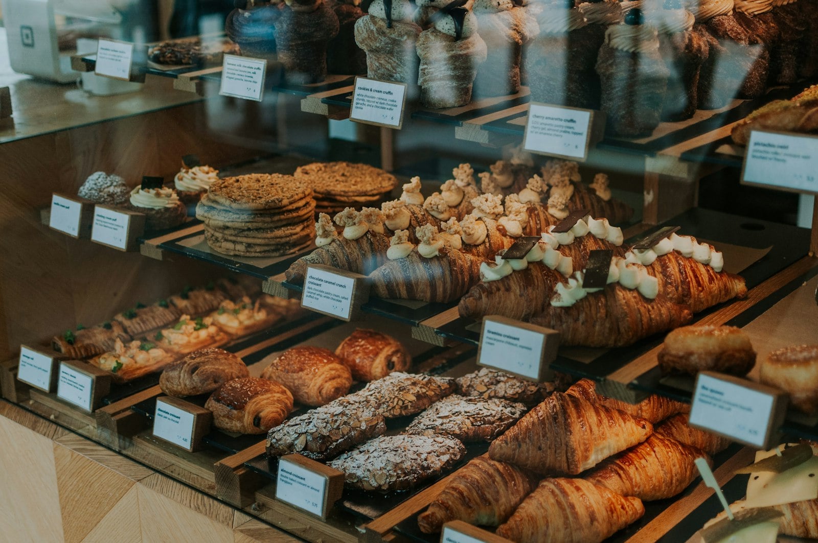 Croissants and pastries stacked in a bakery display case