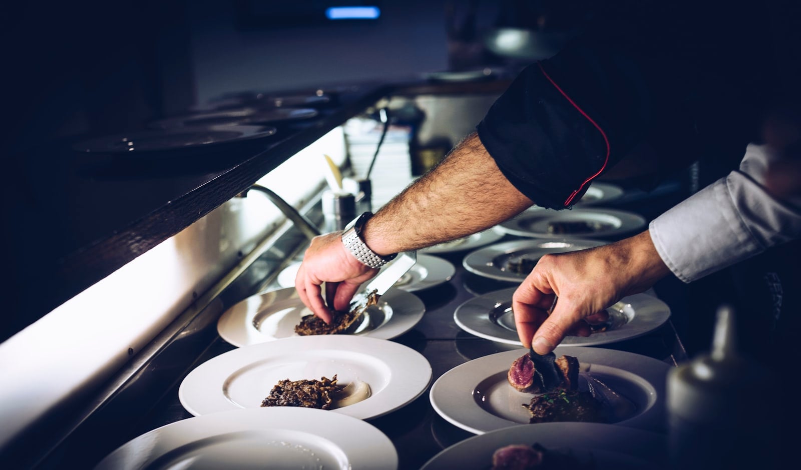 A chef plating a dish in a restaurant kitchen