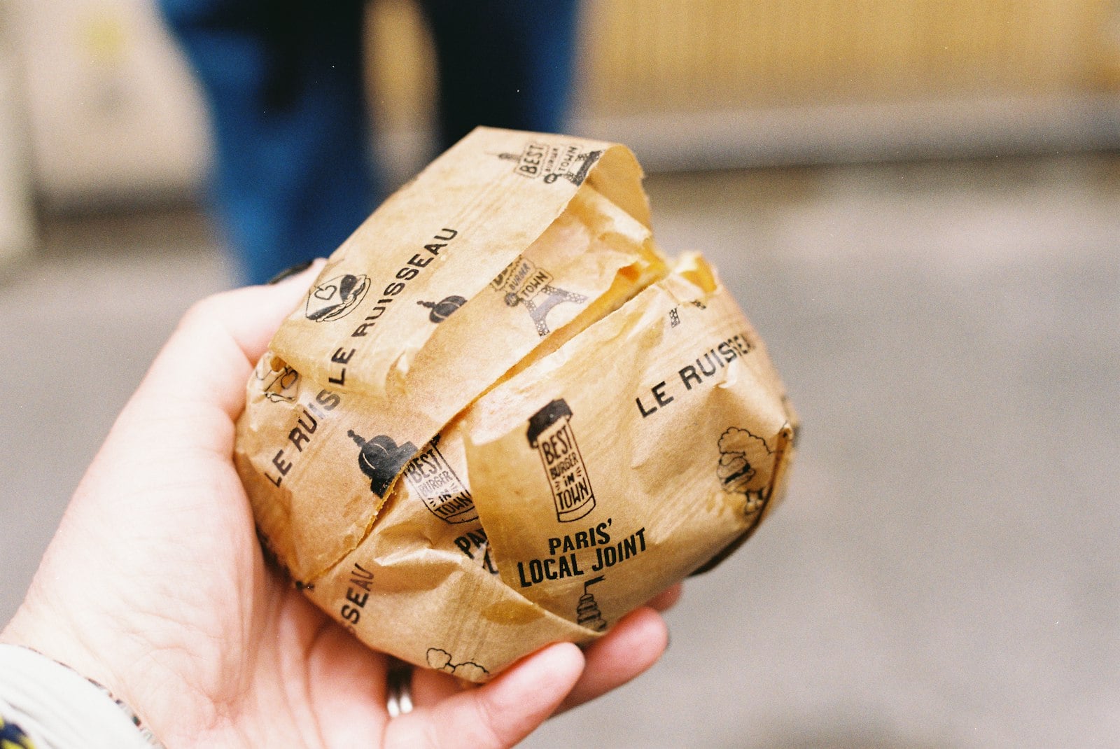A double cheeseburger with crisp-edged patties in a paper wrap