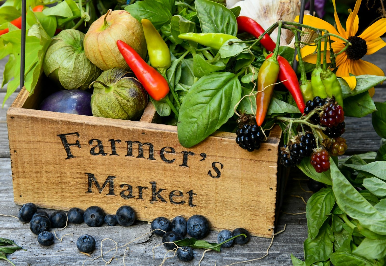 Crates of fresh produce on a table at an outdoor farmers market stall