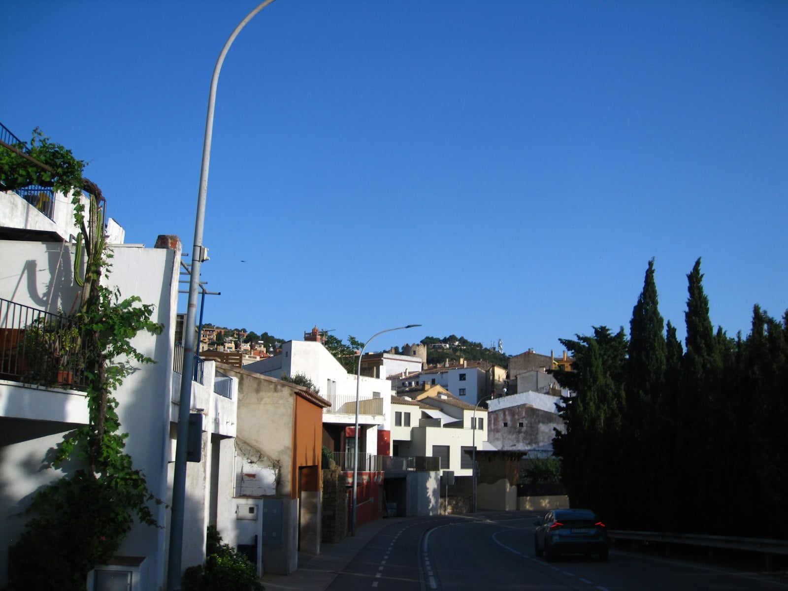 A quiet residential street lined with 1920s houses and ornamental street lamps