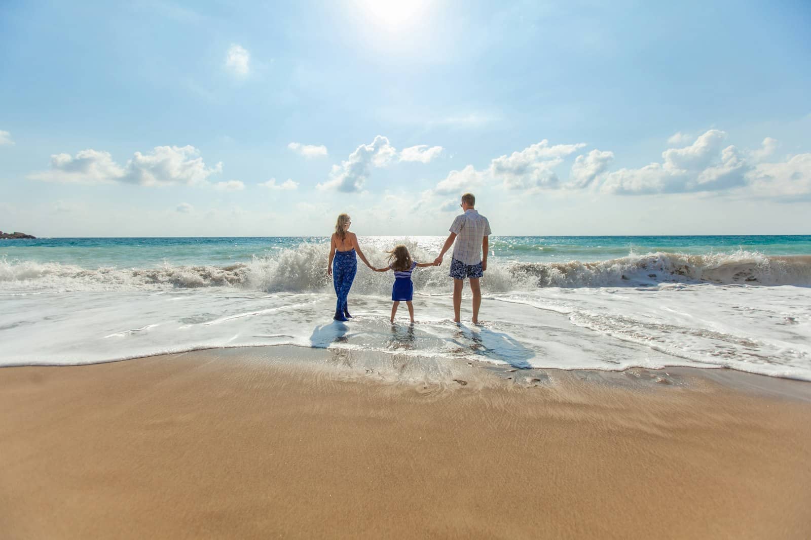 A family walking the shoreline at low tide