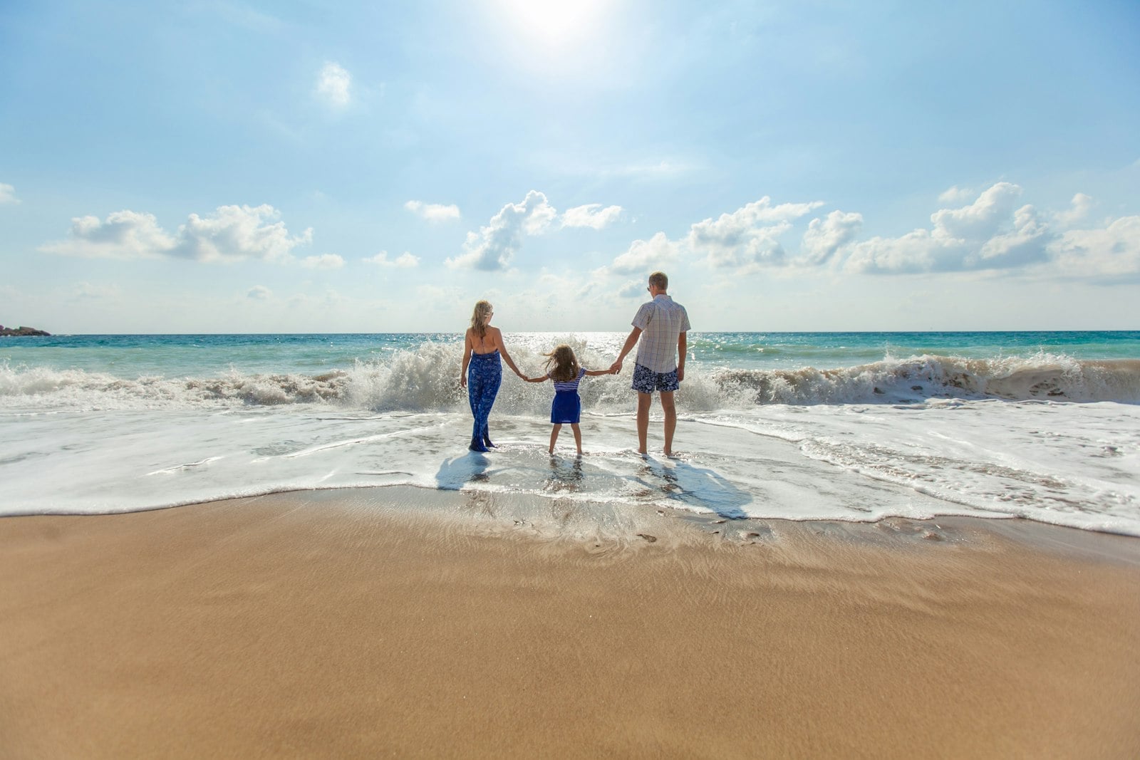 A family walking the shoreline at low tide