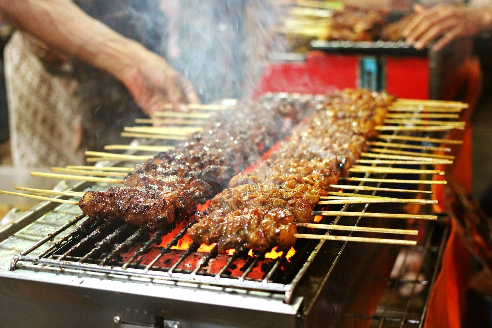 Skewers cooking over a charcoal grill at a neighborhood restaurant