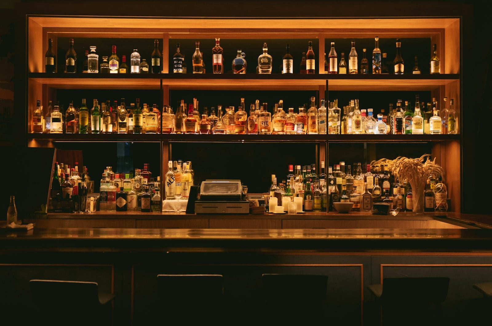 Brown wooden cocktail-bar shelves lined with bottles