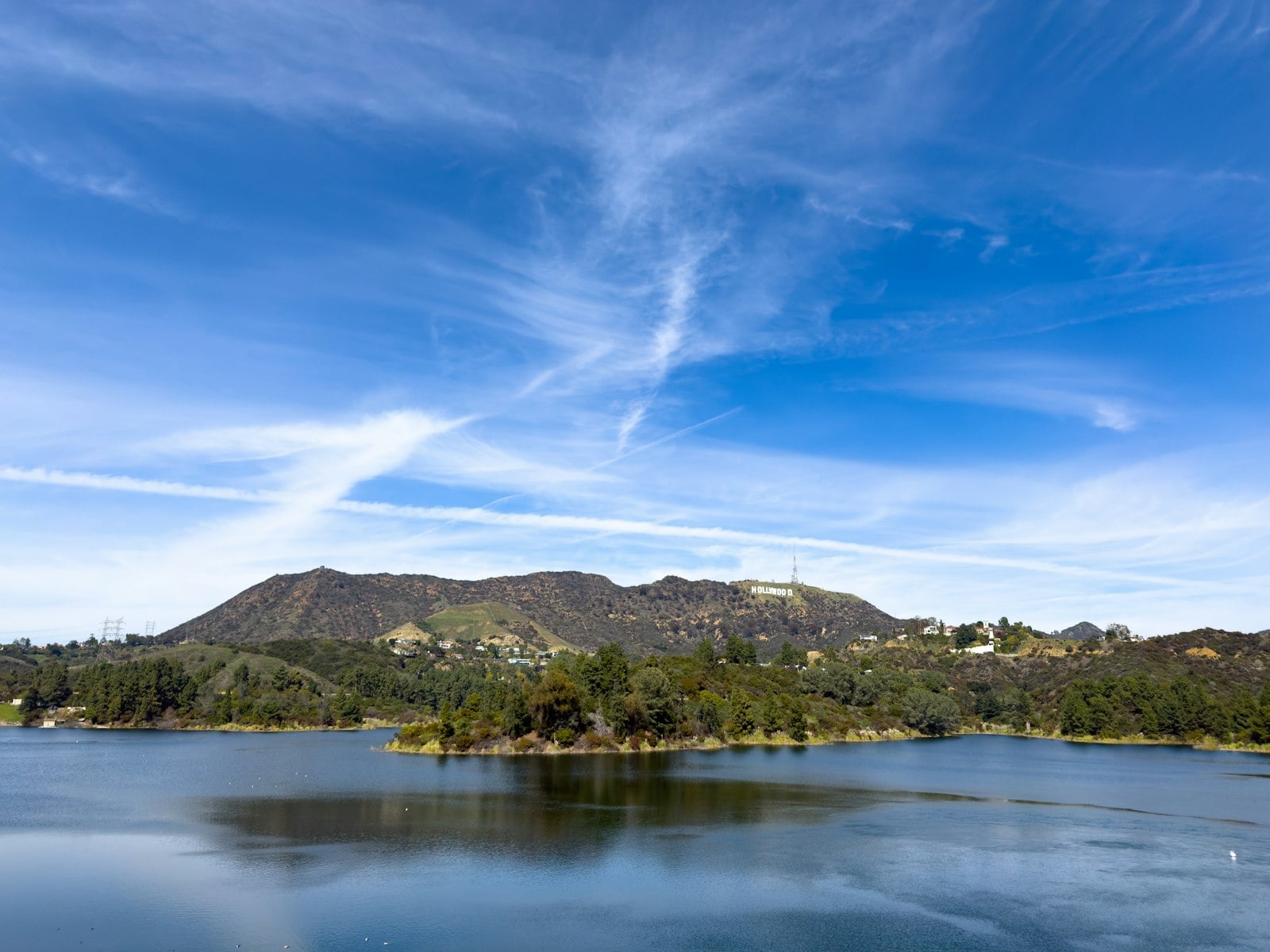 A reservoir below dry hills under a clear blue sky