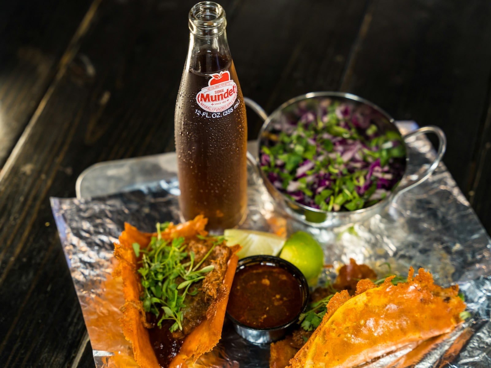 Birria tacos with a bowl of consommé at the table