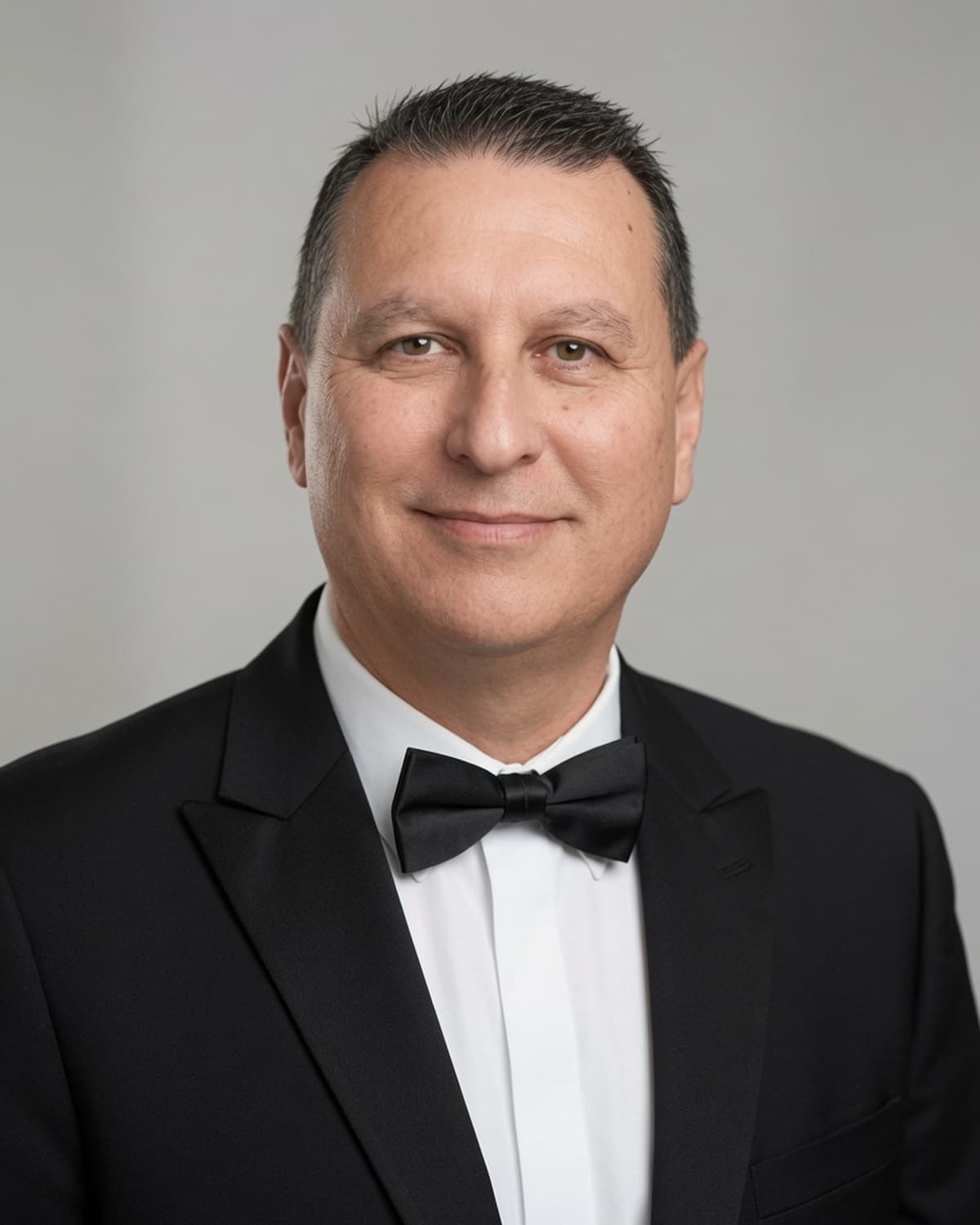 Andrew Gonzalez of Luxury Custom Jeweler, a San Diego custom jeweler, in a black tuxedo and bow tie